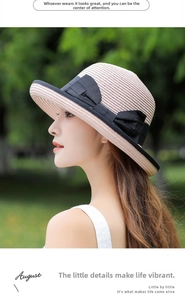 Detail of light beige straw sun hat with black ribbon bow and fine woven texture