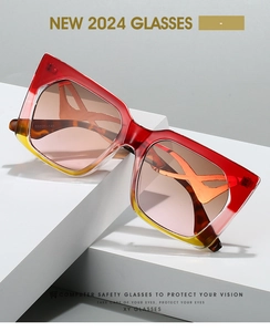 Close-up of cat eye sunglasses with red-yellow gradient frame and tortoiseshell temples