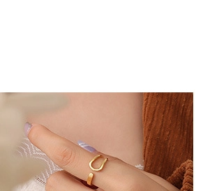 Macro detail of minimalist gold open ring with geometric U-shape on model wearing knitwear