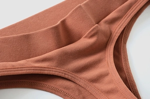 Detail view of caramel ribbed cotton thong showing elastic waistband and stitching