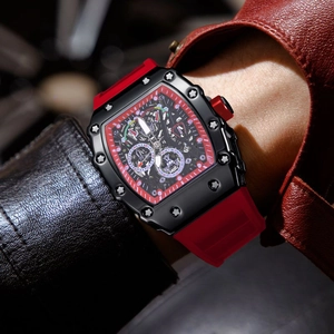 Detalle macro de reloj automático de hombre con correa roja y esfera esqueleto sobre la muñeca