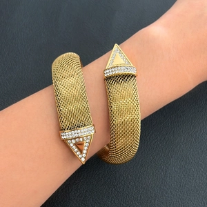 Detailed close-up of 18K gold mesh wrap bracelet featuring sparkling diamond triangle tips