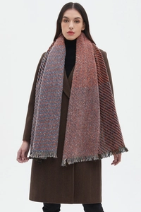 Detail of blue and orange herringbone scarf with tassels on a wool blend texture
