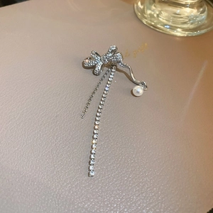 Detail of silver butterfly ear cuff with zircon tassel and pearl on a gift box