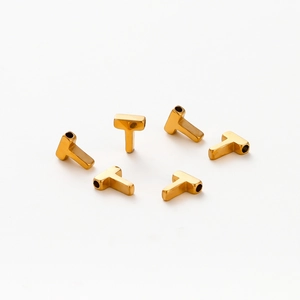 Detail of vacuum gold-plated T-shaped letter beads with smooth metallic finish