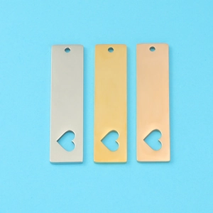 Macro view of rectangular stainless steel tags with heart cutouts in gold silver rose gold