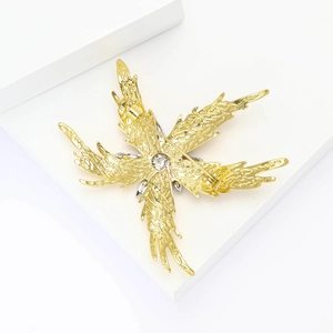 Detail view of gold starfish brooch back with pin clasp and intricate carved texture