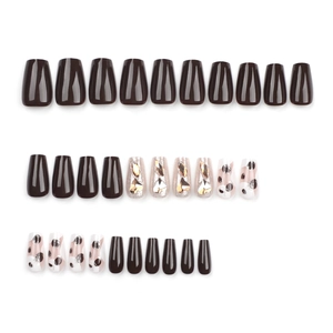 Deep brown press-on nails with sparkling rhinestones and abstract ink patterns