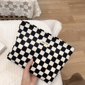 Bolso de mano de pana con patrón de damero y etiqueta Simple Wish sobre fondo madera