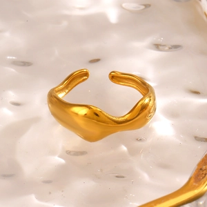 Irregular wave-shaped stainless steel open ring in gold finish on reflective glass
