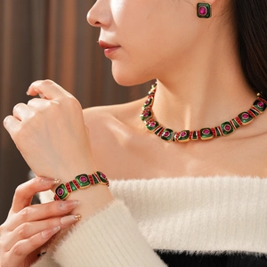 Detailed close-up of vintage jewelry set featuring green enamel and pink gemstones