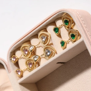 Three pairs of heart-shaped gold stud earrings with pink, white and green crystals