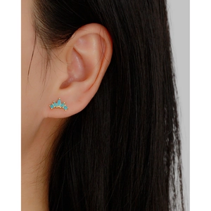 Macro shot of crown stud earring with blue zircon stone on gold-plated sterling silver