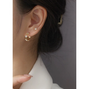 Macro detail of gold flower cluster hoop earrings and stud set with white mother of pearl
