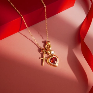 Detail der goldenen Titanstahlkette mit Herzrubin-, Kreuz- und Zirkonia-Anhängern