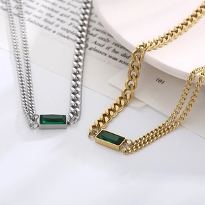Detailed close-up of emerald zircon pendant necklace with mixed Cuban and cross link chain