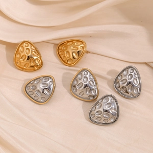 Macro shot of 18K gold and silver irregular triangle earrings with hammered texture