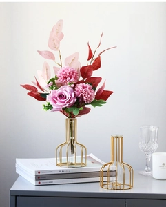 Close-up of golden metal test tube flower vases with glass containers for home decor