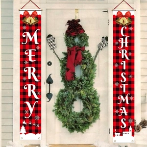 Detail of red and black plaid Merry Christmas door banners on a white front entry door