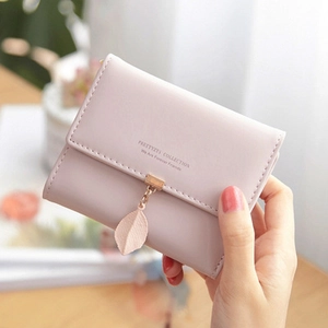 Close-up of pale pink PU leather trifold wallet with leaf pendant and metal buckle
