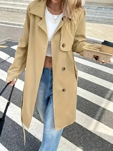 Elegant khaki long trench coat with notched lapel and waist belt for women in street style