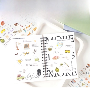 Macro view of spiral notebook with colorful hand-drawn theme stickers for DIY journal craft