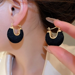 Close-up of vintage black flocked and gold horseshoe-shaped U-type earrings