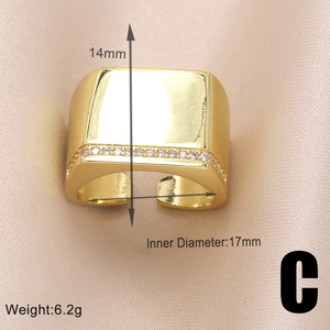 Detail showing dimensions of gold geometric ring with zircon stones on silk fabric