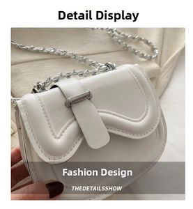Detail view of white PU leather saddle bag with wavy flap and silver chain strap