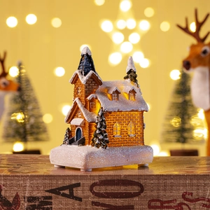 Close-up of a Christmas glowing resin house with LED lights and warm bokeh background