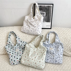 Detail of quilted cotton tote bags featuring colorful star and animal print patterns