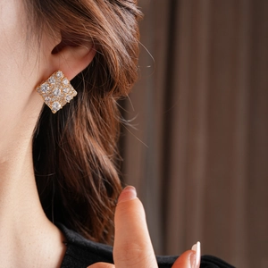 Gros plan détaillé d'une boucle d'oreille carrée plaquée or avec micro-pavé de zircons