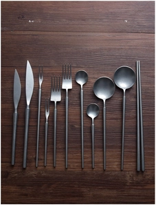 Flat lay of 10-piece matte silver 304 stainless steel cutlery set on dark wood