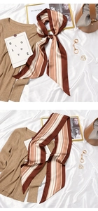 Detail view of a vintage striped silk scarf tied on a bag with soft brown and beige tones