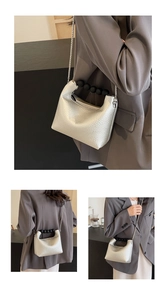 Detail of silver lychee grain leather crossbody bag with black beaded handle and chain