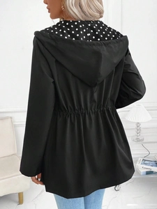 Detail der Kapuzenjacke mit schwarzer Außenseite und stilvollem weißen Punktfutter