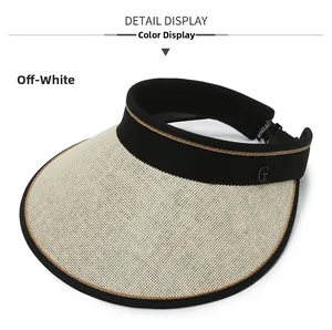Detail of beige straw sun visor with black fabric headband and gold G logo decoration