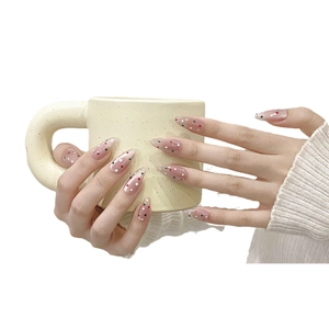 Uñas postizas de almendra con base rosa gelatina translúcida y lunares de colores