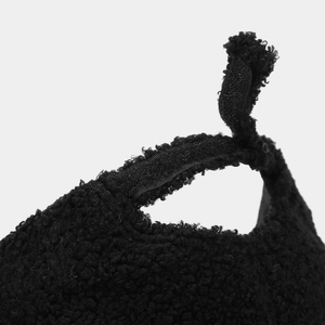 Close-up of the black fuzzy fleece baseball cap featuring an adjustable velcro strap back