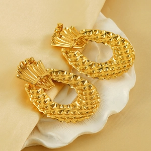 Golden textured geometric earrings with 18K plating on satin fabric for a modern look
