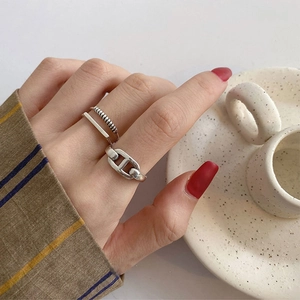 Nahaufnahme von silbernem Schweinenasen-Kettenring und minimalistischen Ringen