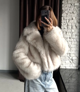 Close-up of beige faux fox fur jacket showing dense plush texture and large lapel detail