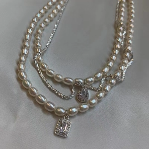 Three-layer vintage necklace with rice pearls, silver chains and zircon drop pendants