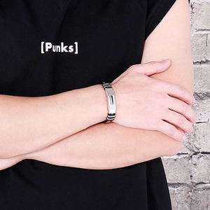 Close-up of a men's black braided silicone and steel bracelet in a punk street style