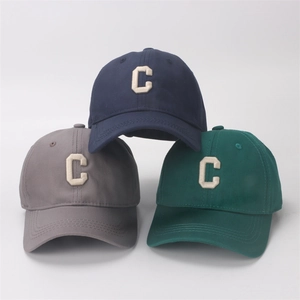 Detailed shot of stackable cotton twill baseball caps with embroidered C in navy, grey, and green