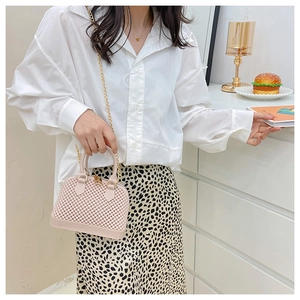 Detailed shot of pink jelly bag with gold chain strap on a leopard print skirt backdrop