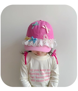 Detail of pink girls baseball cap with pastel bows, white lace trim and pearl accents