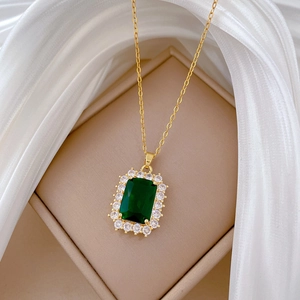 Elegant gold necklace with emerald green rectangle pendant and sparkling halo setting