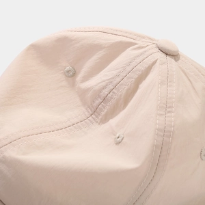 Macro shot of breathable beige quick-dry fabric and stitching on a baseball cap