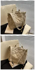 Detail of beige quilted tote bag showing rhombus stitching and side pocket in soft light